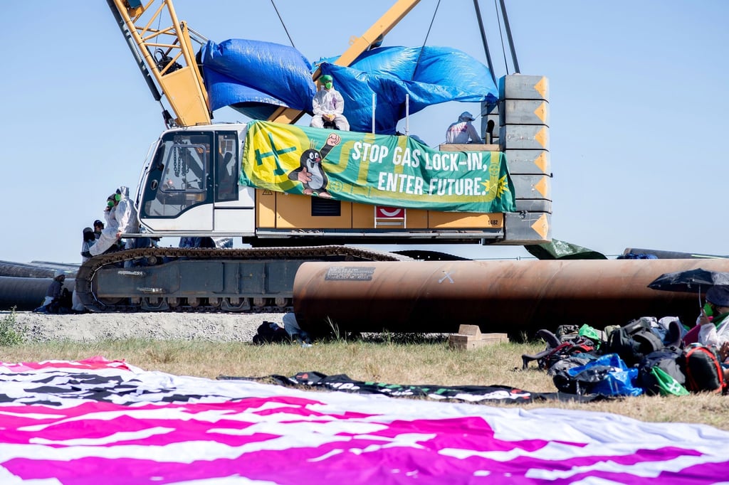 Transparent mit der Aufschrift „Stop Gas Lock-In, Enter Future.“ an einem Kran auf der Baustelle für die geplante Gaspipeline in Wilhelmshaven.