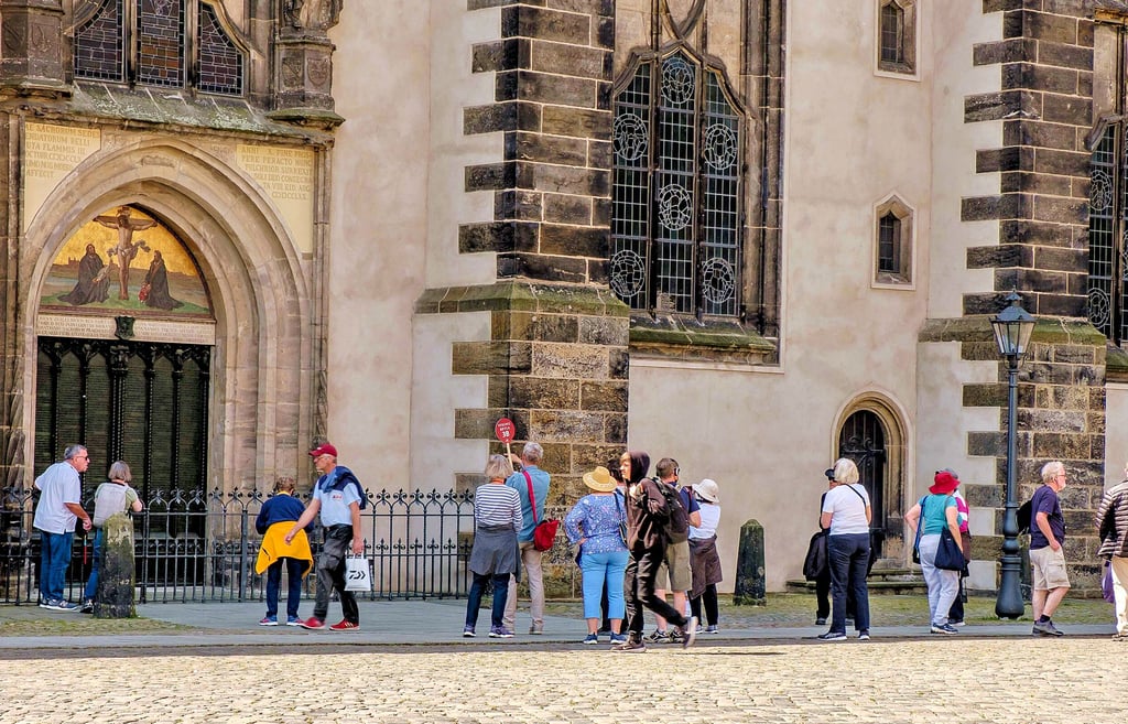 Touristen an der Thesentür. Die Schlosskirche ist einer der Hauptanziehungspunkte in der Lutherstadt.