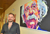 Der Magdeburger Künstler Carlo Bzdok neben seinem Porträt von Albert Einstein.