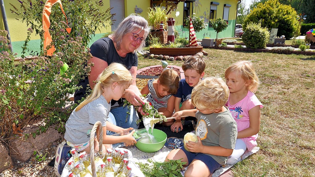 Kita-Leiterin Ute Lier stellt mit Luise, Lotta, Ole, Emely und Jonas (von links) Pfefferminzsirup her.