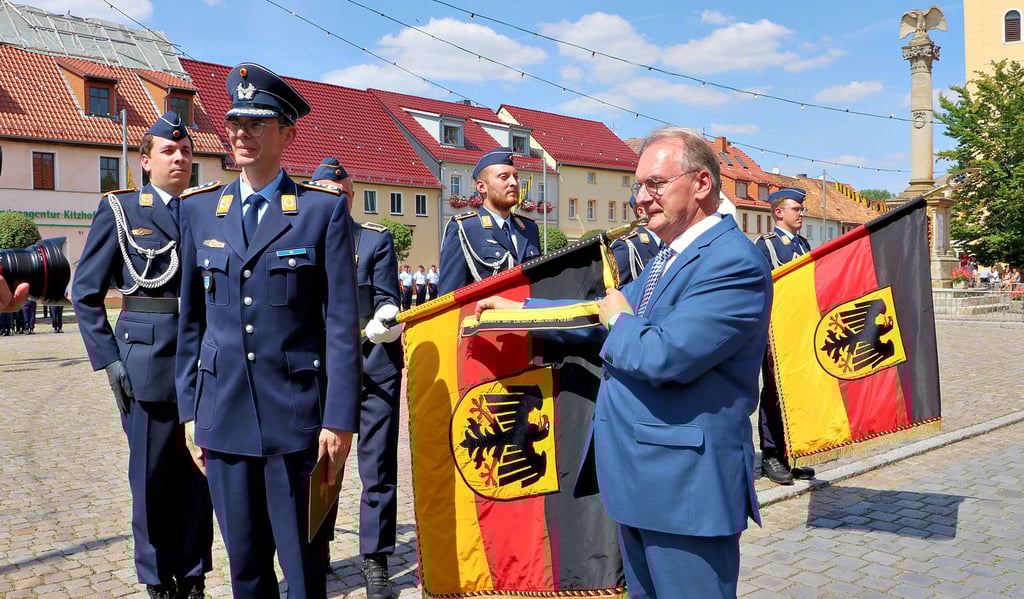 Ministerpräsident Reiner Haseloff verleiht das Fahnenband auf dem Markt in Jessen zunächst an den Holzdorfer Einsatzführungsbereich 3 und dann an die Lufttransportgruppe des Hubschraubergeschwaders 64.