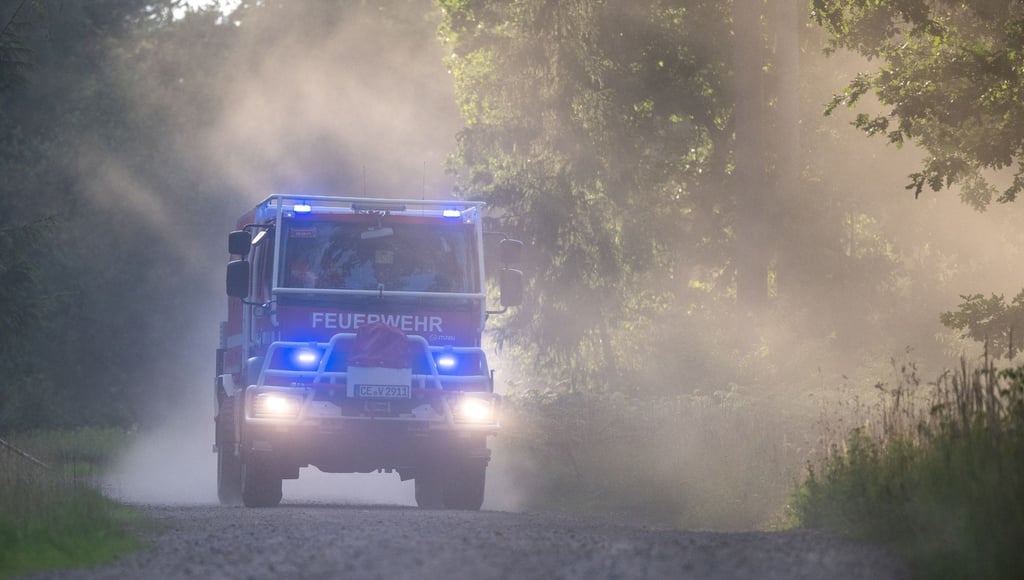 Ehrenamtliche Feuerwehrkräfte fahren mit dem Waldbrandtanklöschfahrzeug "CCFM 3000" zum Einsatzort.