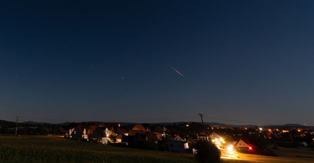 Eine Sternschnuppe verglüht am Nachthimmel über Höfen in Bayern.