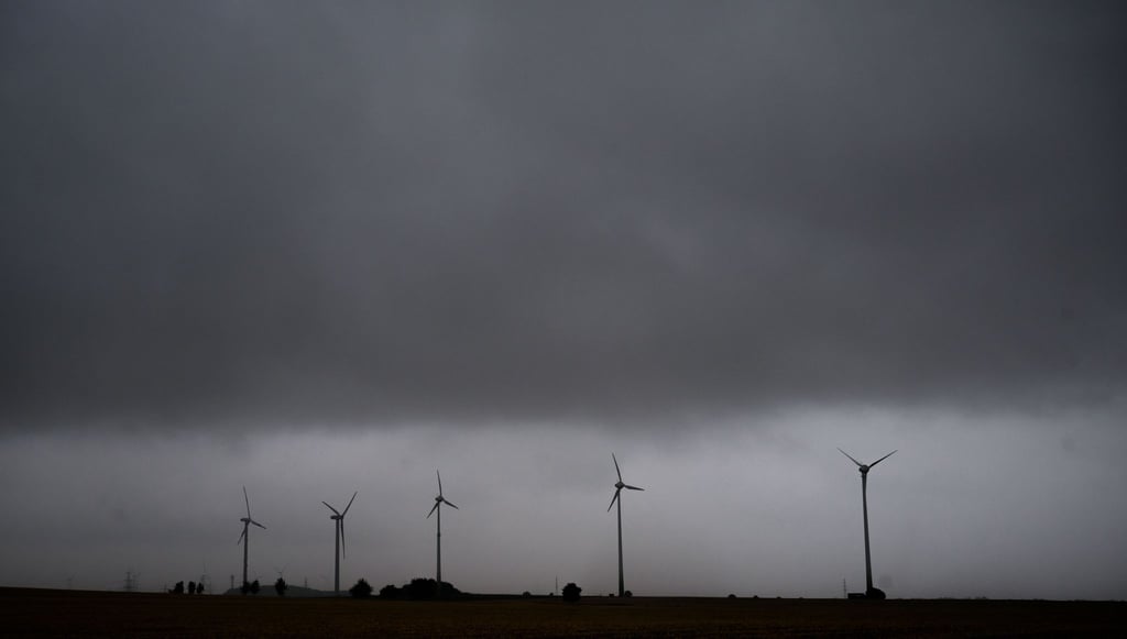 Eine Gewitterfront mit Starkregen zieht über Windräder in der Region Hannover hinweg.