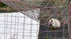 Ein Fußball liegt auf dem Tornetz (Symbolbild).