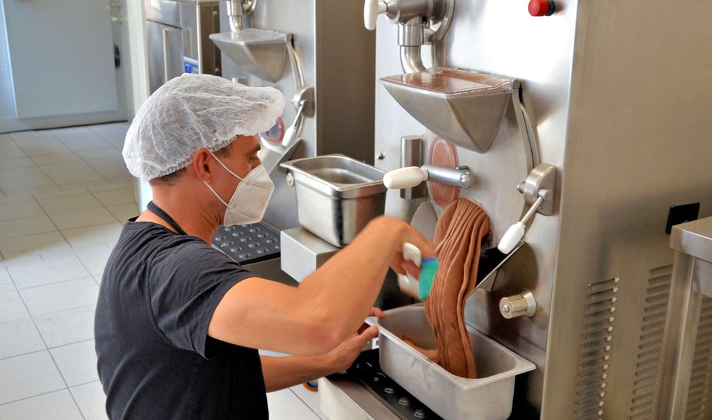 „Eiskoch“ Sebastian Elster an der Maschine, die das wichtigste Produkt der Langenweddinger herstellt.