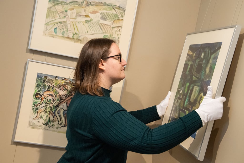 Kunsthistorikerin Mandy Wignanek hängt Bilder mit Wein-Motiven von Walter Weiße im Weinmuseum auf Schloss Neuenburg auf. Sie beschäftigt sich auch mit dem Nachlass Weißes.