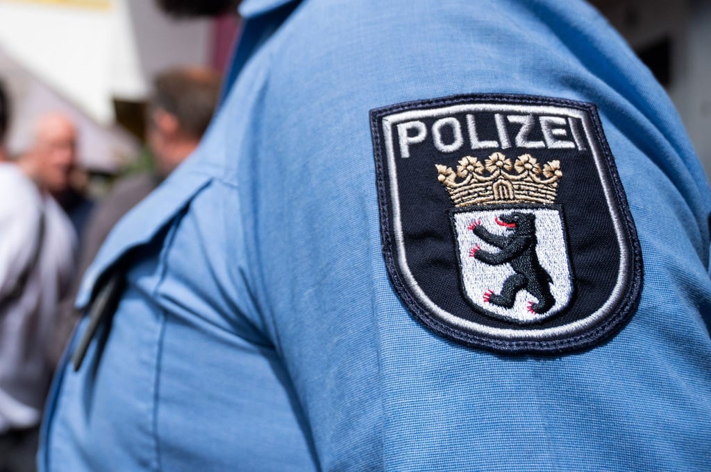 Ein Polizist steht während einer Pressekonferenz vor der geplanten neuen Polizeiwache.