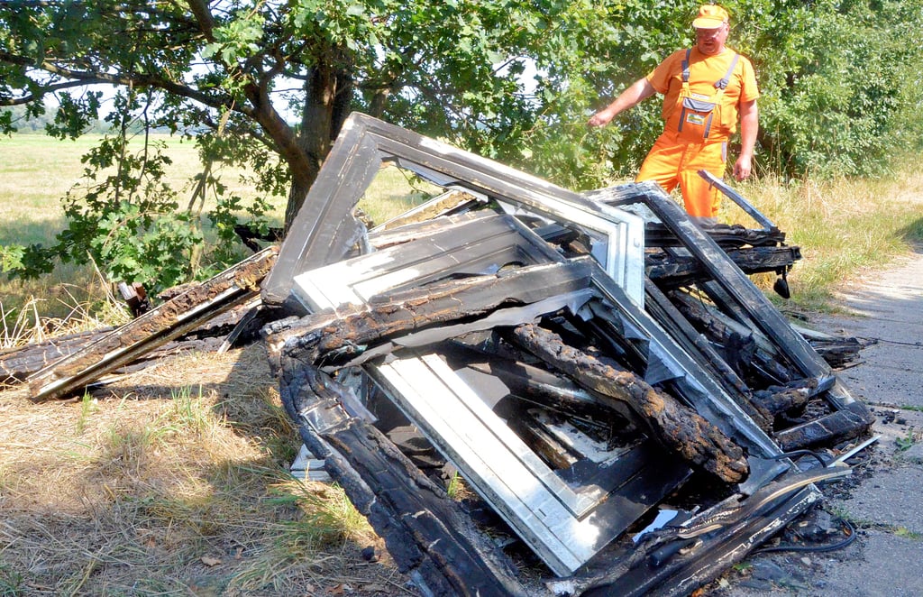 Volker Senitz, Mitarbeiter der Deponie GmbH, an den verbrannten Fenstern und Türen am Kolonnenweg bei Chüttlitz. Er schätzt, dass diese ungefährt anderthalb Tonnen wiegen und mit einem Kran geborgen werden müssen.