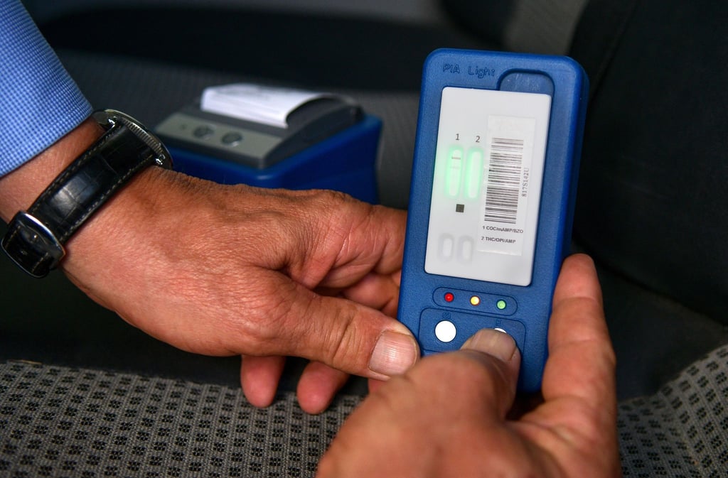 Ein Techniker demonstriert bei einer Kontrolle von Verkehrsteilnehmern ein Drogentestgerät.