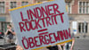 Ein Teilnehmer an der Demonstration "Lindner raus - Umverteilung jetzt!" steht mit einem Plakat vor der FDP-Bundesgeschäftsstelle.