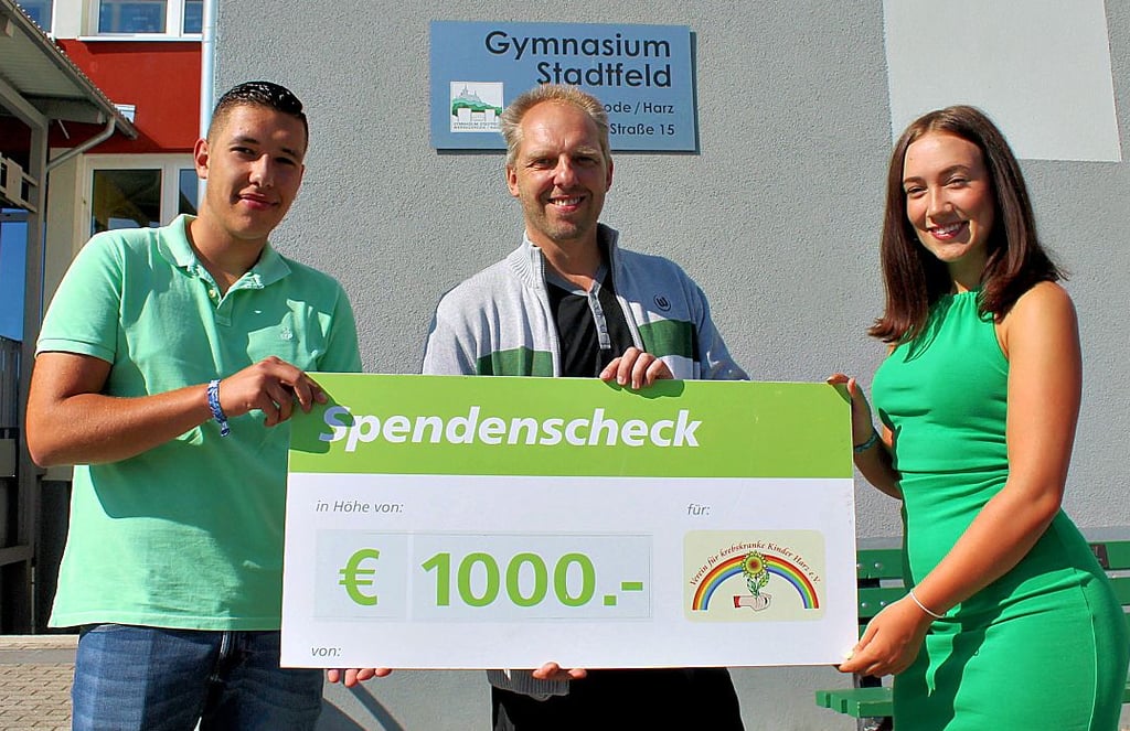 Avery Kolle (Mitte) vom Verein für krebskranke Kinder Harz feut sich über die 1000 Euro, die ihm Lucy Kranz und Noah Filipek vom Stadtfeld-Gymnasium Wernigerode überreichen.