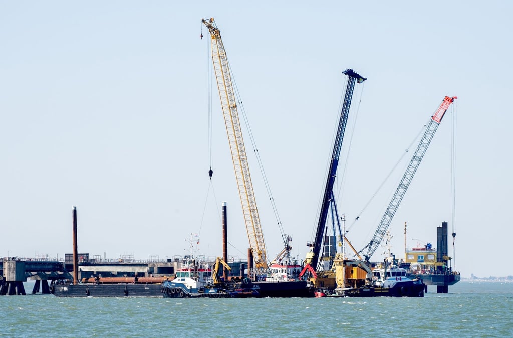 Mehrere Pontons und Schwimmkrane liegen an der Baustelle für das geplante LNG-Terminal.