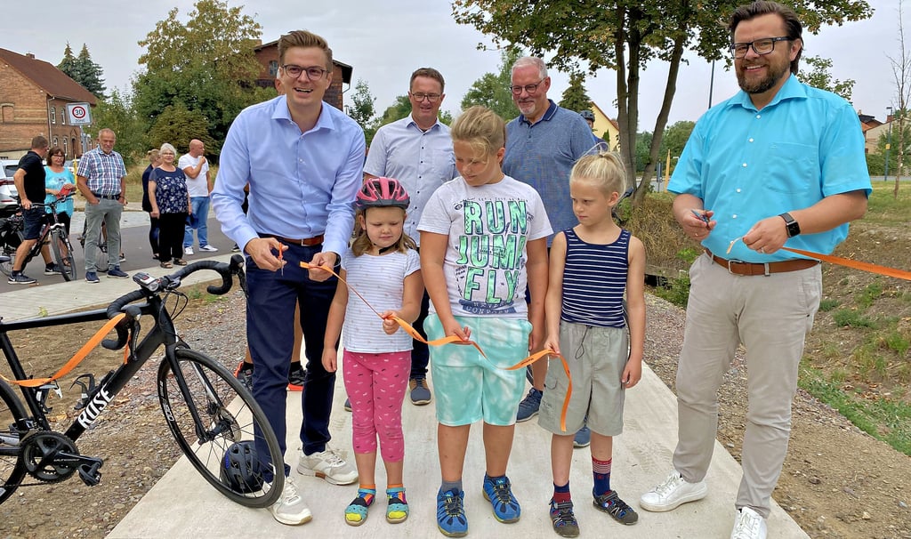 Staatssekretär Sven Haller (links) und Huy-Bürgermeister Maik Berger (rechts) zerschneiden gemeinsam mit einigen Kindern aus der Region das obligatorische Band. Dahinter ebenfalls mit dabei: Rainer Fricke vom zuständigen Planungsbüro und der Landtagsabgeordnete Thomas Krüger, der vor Jahren in seiner Amtszeit als Bürgermeister das Projekt auf den Weg gebracht hatte.