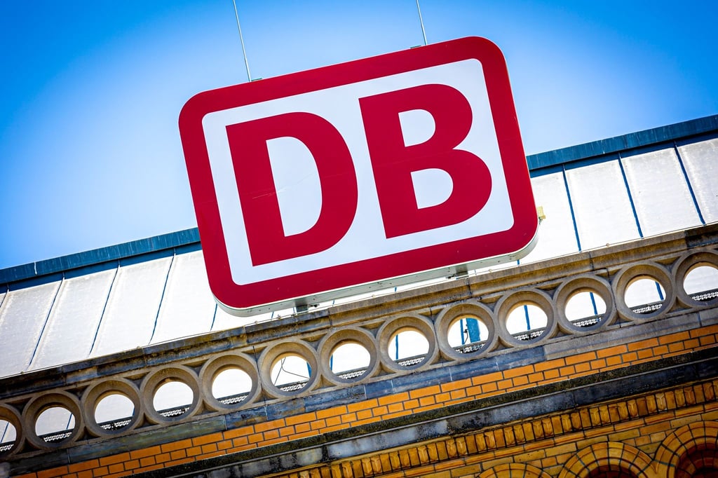 Das Logo der Deutschen Bahn AG ist an einem Bahnhof zu sehen.