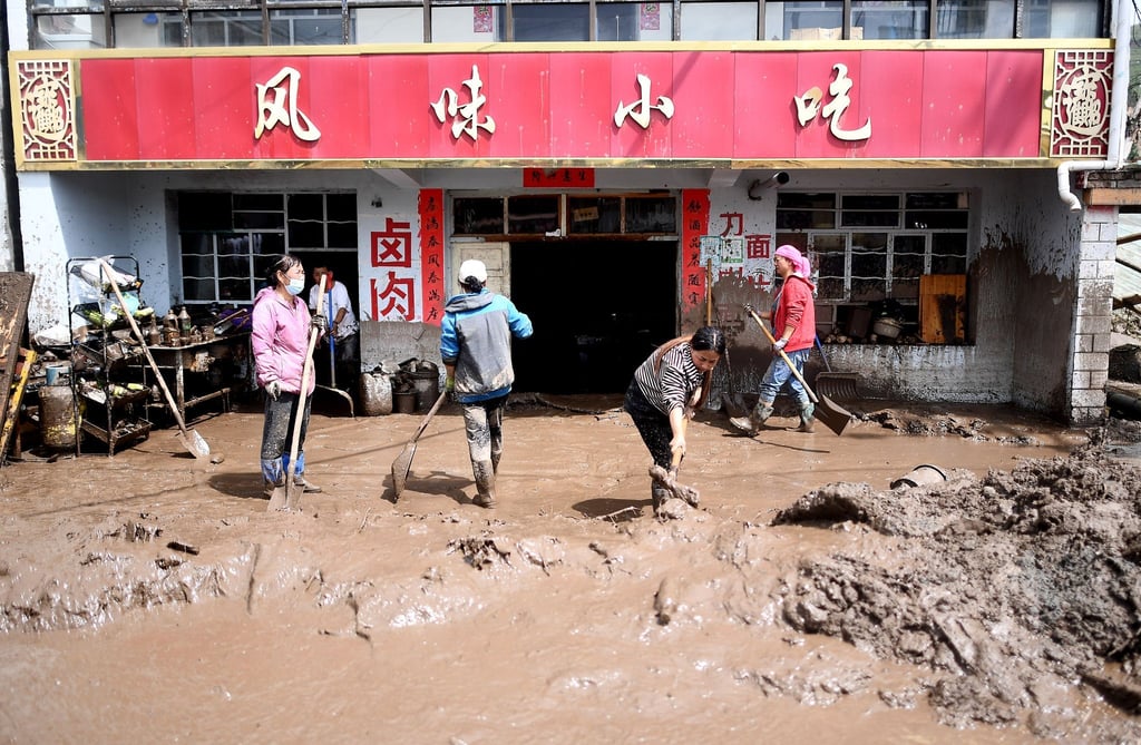 Anwohner entfernen Schlamm von ihrem Grundstück in der nordwestchinesischen Provinz Qinghai.