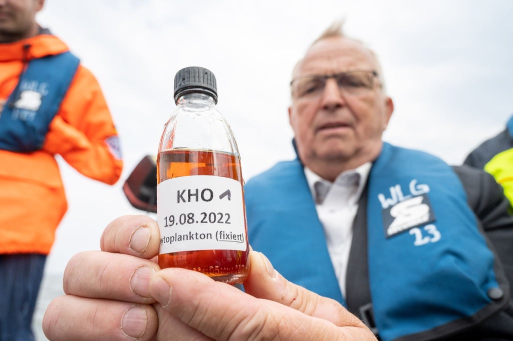 Till Backhaus (SPD)zeigt eine chemisch fixierte Wasserprobe aus dem Stettiner Haff.