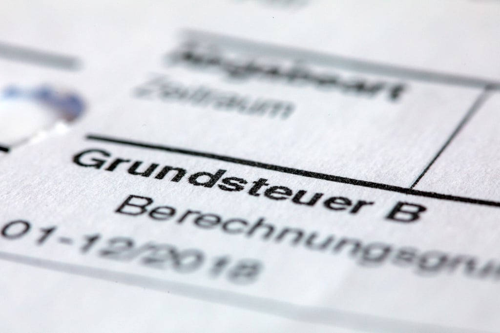 Ein Abgabenbescheid für die Entrichtung der Grundsteuer liegt auf einem Schreibtisch.