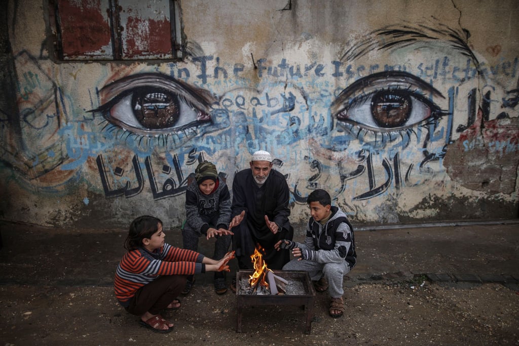 Palästinensische Kinder wärmen sich mit ihrem Großvater an einem Feuer in Gaza-Stadt (Archiv).