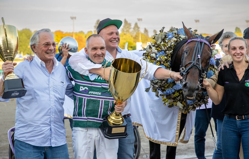 PThorsten Tietz (2.v.l) gewinnt mit dem Pferd Days of Thunder das Finale des Deutschen Traber-Derbys.