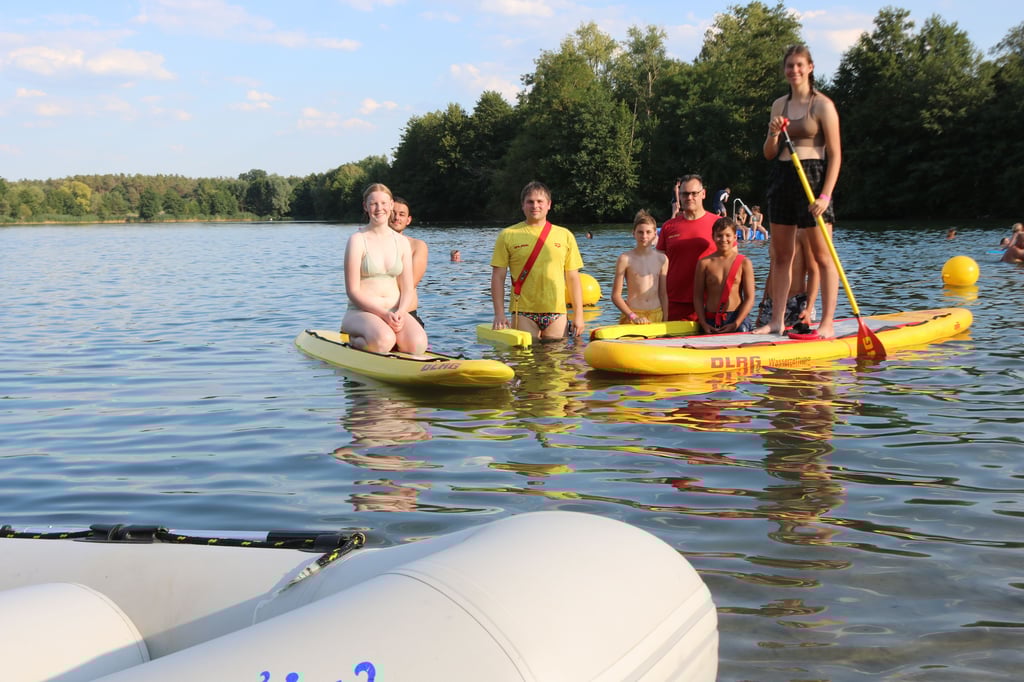 Mitglieder der Jugendgruppe des DLRG Genthin mit Trainer Martin Bessert (3. v. l.) am Zabakucker See mit neuem Stand-up-Board (r.)