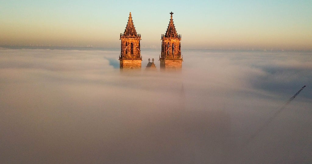Der Magdeburger Dom. Bei bestimmten Wetterlage ragen seine Türme aus dem Neben heraus.