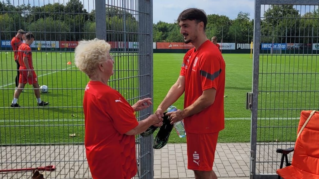 HFC-Edelfan Helga Noffke begrüßt Albion Avdijaj am Trainingsplatz.