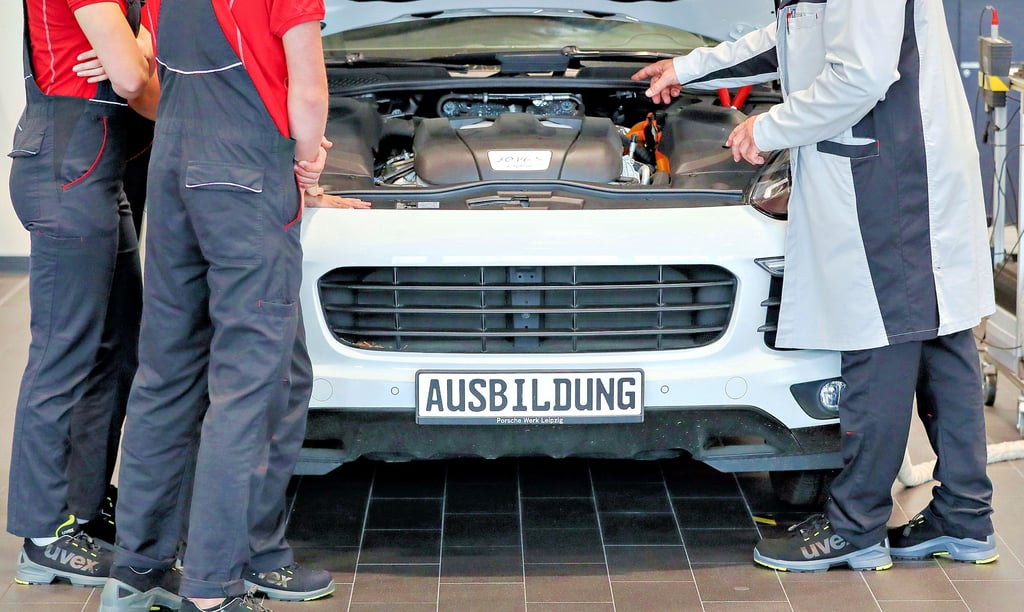 Zwei Auszubildende bei Porsche lernen die Funktionsweise des Hybridantriebes. Auch die großen Unternehmen merken den Rückgang an Auszubildenden, die der demografische Wandel mit sich bringt, für kleinere Betriebe im ländlichen Raum ist die Situation aber vielfach prekärer.