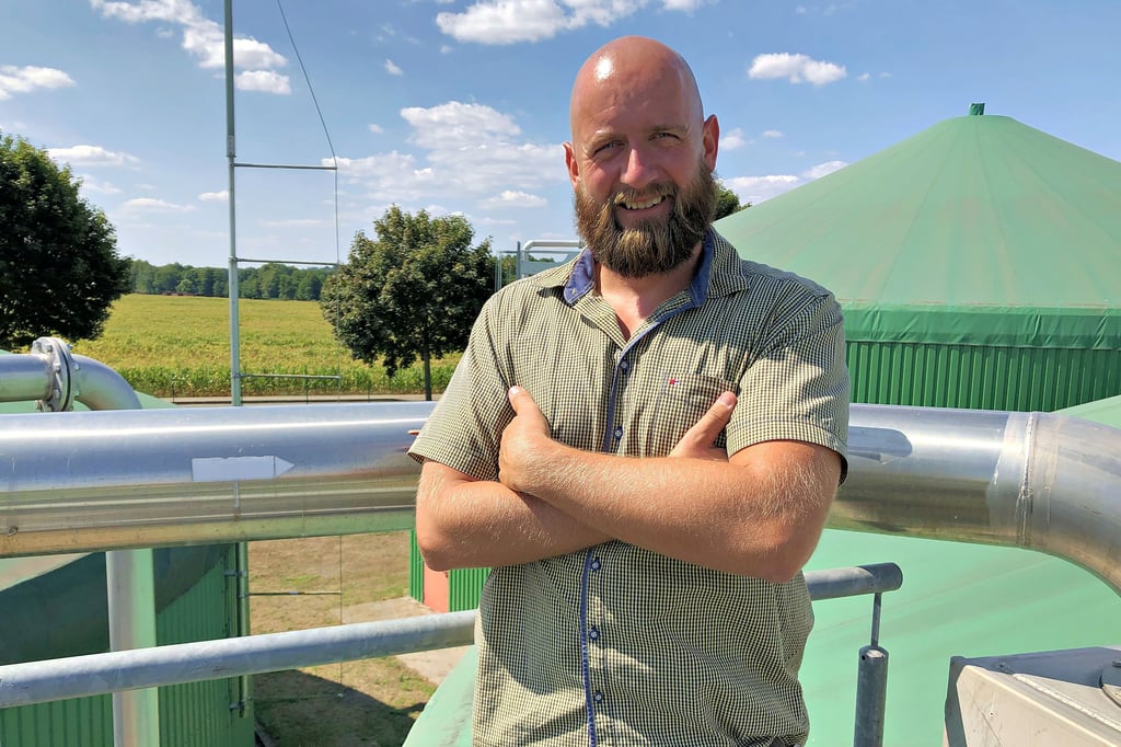 Christian Raapke, Geschäftsführer der Agrargenossenschaft in Tengeln in der Altmark gibt Gas: Rechts hinter ihm steht einer der Behälter, in denen aus Gülle und Pflanzensilage Biogas entsteht. Das Futter für die Anlage kommt unter anderem von dem Maisfeld im Hintergrund.