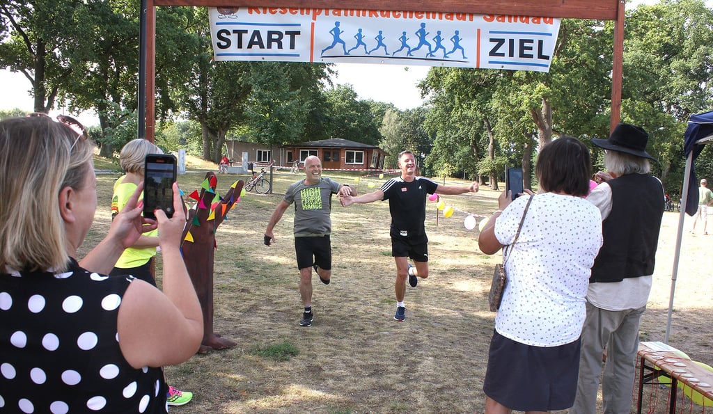Bernd Starke aus Osterburg und Martin Quante aus Wahrendorf erreichen nach 3,9 Kilometern gemeinsam das Ziel am Kamernschen Strand. Von Angehörigen und Freunden werden sie dort schon erwartet.