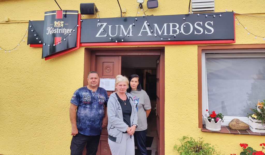 Thomas Abel, Inhaber vom Gasthof Zum Amboss (von links), Ukraine-Geflüchtete Svetlana Sharapova und Gasthof-Mitarbeiterin Anastasia Kokoreva stehen am Eingang zum Gasthof in Poserna.