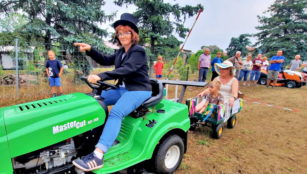 Joyce Sattran fährt schick gekleidet mit dem Eulenmobil voraus und zeigt den Teilnehmern des Traktorrennens den Parcours.