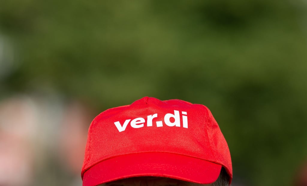 Ein Angestellter trägt eine Mütze mit dem Verdi-Logo.