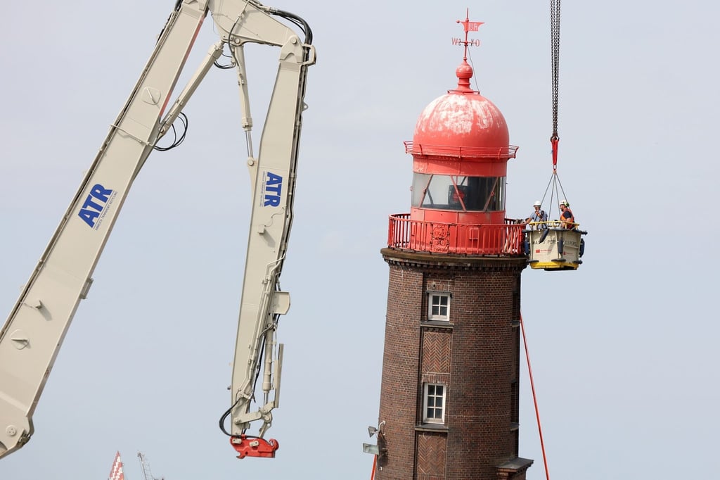 Experten schauen sich bei einer Inspektion den schiefen Leuchtturm in Bremerhaven an.
