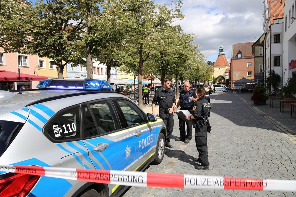 Polizeibeamte stehen bei dem Einsatz in Weiden/Oberpfalz. Eine Frau hatte im Stadtzentrum mehrere Menschen verletzt.