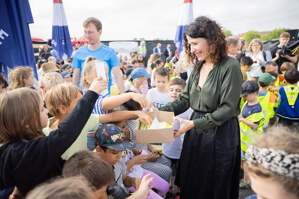 Bettina Jarasch (Bündnis 90/Die Grünen), Berliner Senatorin für Umwelt, Verkehr, Klima- und Verbraucherschutz, verteilt beim Verkehrssicherheitstag auf dem Tempelhofer Feld Reflektoren.