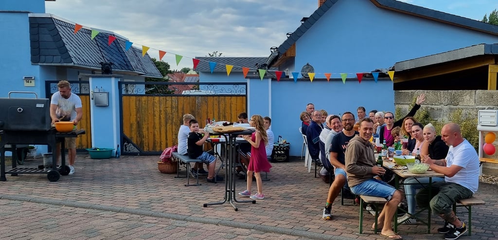 Grillgemütlichkeit in der Ummendorfer Straße Maulbeergarten. Die Nachbarschaft hatte sich zusammengefunden, um auf die neue Familie anzustoßen, die das Geschehen von ein paar Metern weiter oben beäugte.