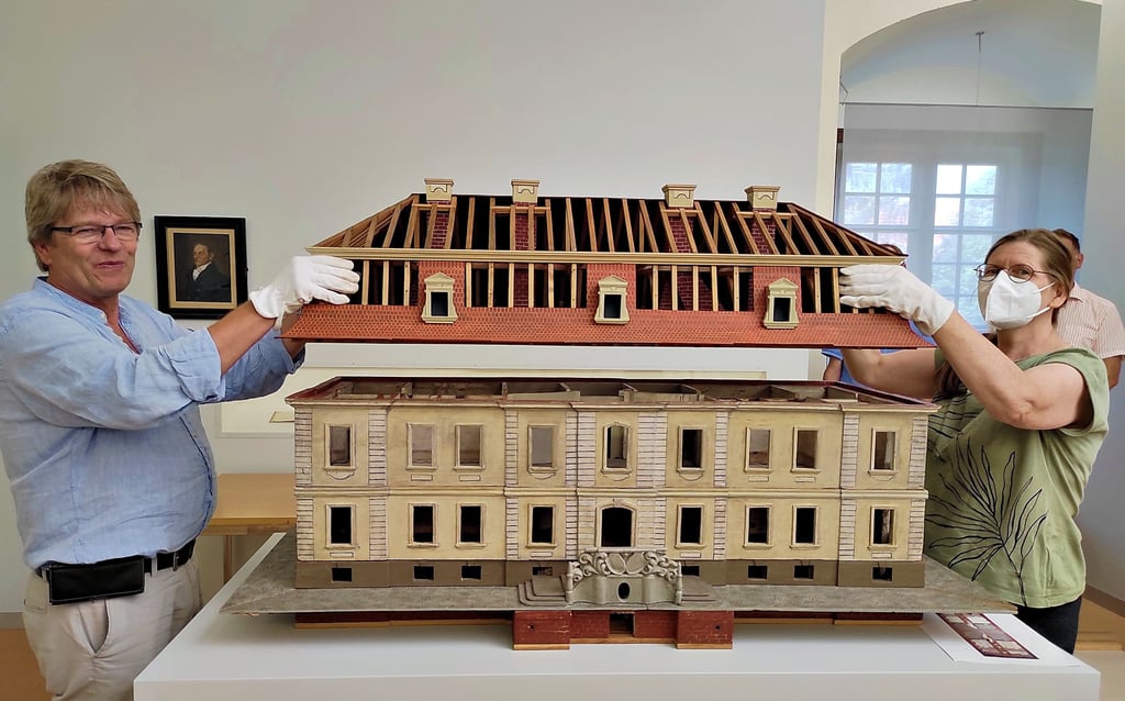 Robert Hartmann (Kulturstiftung Dessau-Wörlitz) und Karin Weigt vom Stadtgeschichtsmuseum heben das Dach vom Schloss des Kühnschen Prinzen.