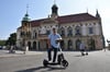 Boris M. Hillmann mit einem „Yoio“-Scooter vor dem Rathaus in Magdeburg. 150 dieser Elektrofahrzeuge sind in der Stadt unterwegs. 