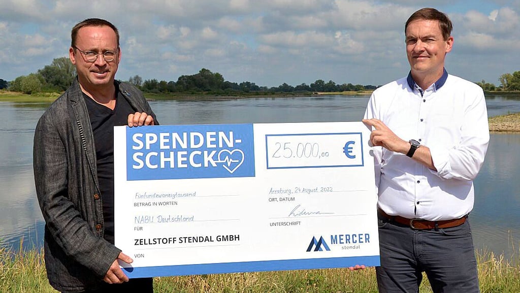 Leif Miller (links), Geschäftsführer des Nabu-Bundesvorstandes, nimmt die Spende in Höhe von 25.000 Euro von André Listemann, Geschäftsführer Mercer Stendal, an der Elbe entgegen.