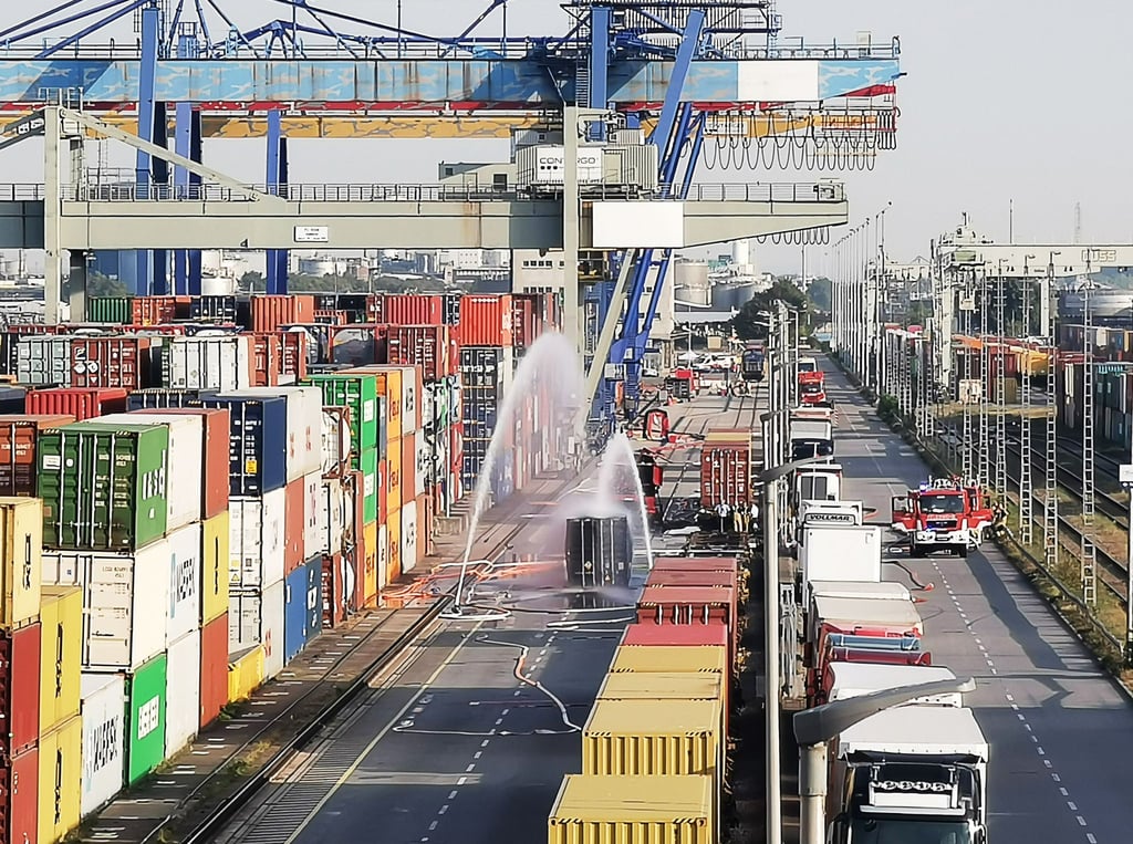Die Feuerwehr kühlt im Mannheimer Hafen den Container, der mit 200 Fässern Hydrosulfit gefüllt ist.