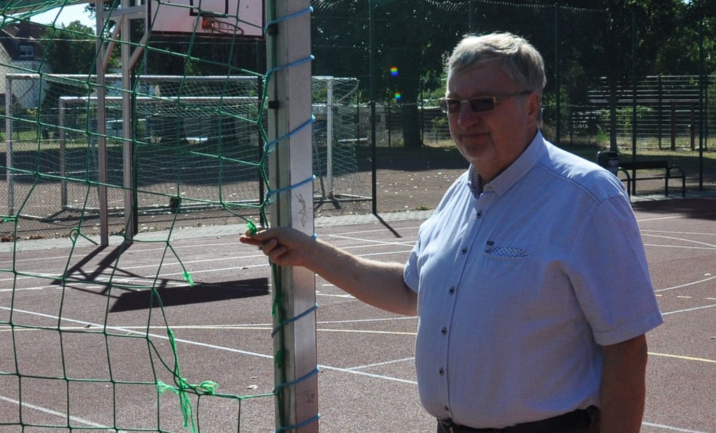 Stadtmitte-Schulleiter Ingo Doßmann zeigt das zerstörte Tornetz auf dem Sportplatz auf dem Schulgelände.