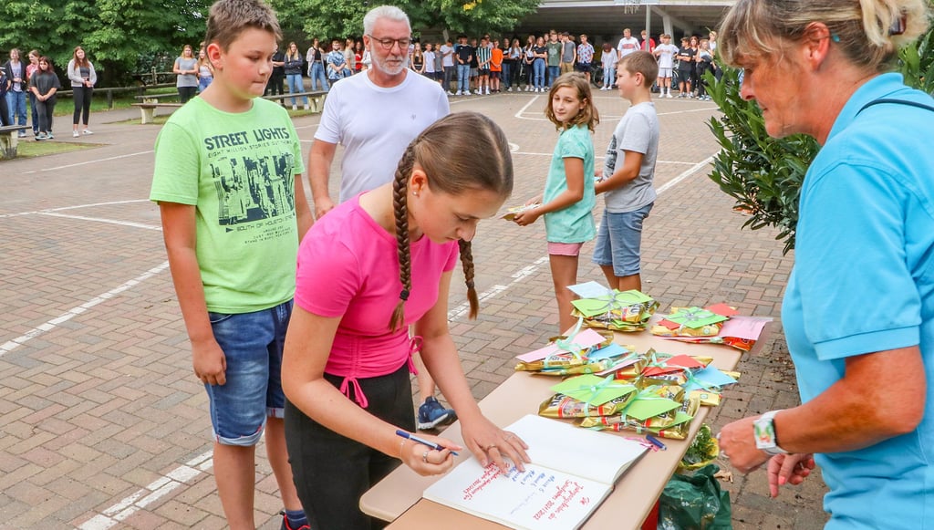 Mia Dittmann schreibt sich als Jahrgangsbeste in das Goldene Buch der Sekundarschule Elster ein.