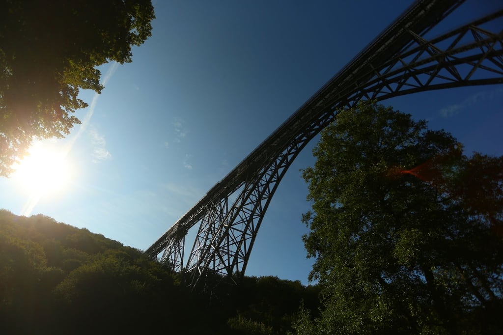 Die Müngstener Eisenbahnbrücke, eine Bogenfachwerkbrücke aus Stahl, führt über ein Tal der Wupper.