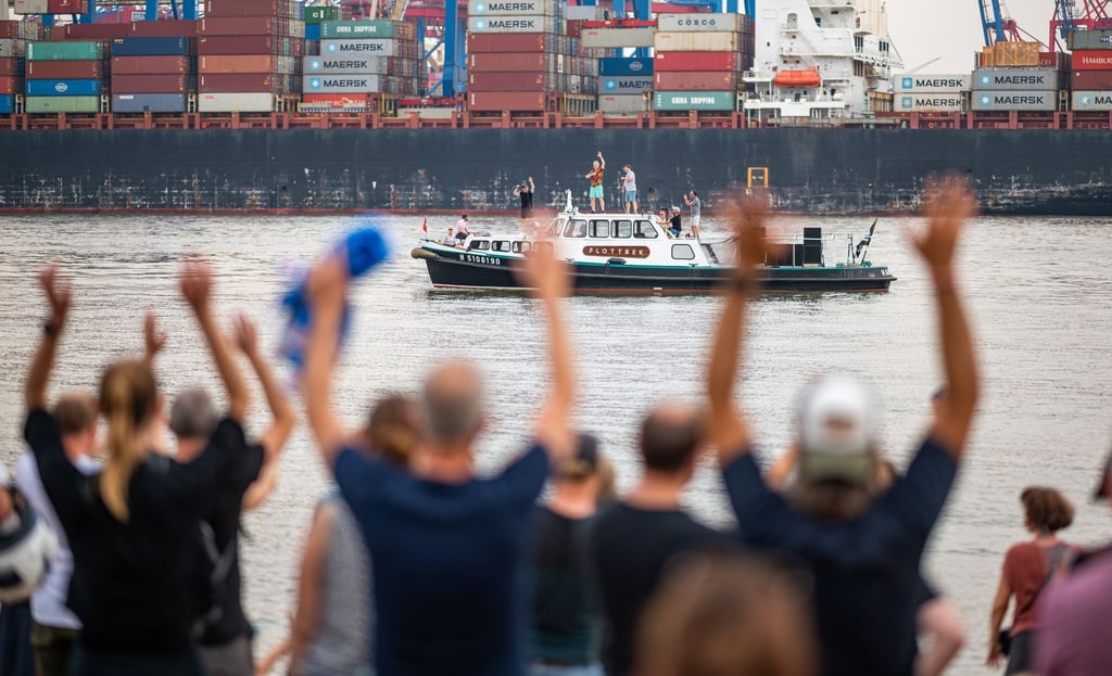 Die Band Fettes Brot tritt auf einem Boot auf der Elbe vor dem Elbstrand auf.