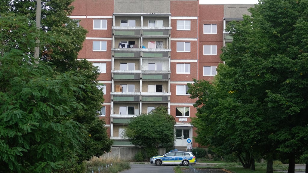 Ein Funkwagen der Polizei steht vor einer Unterkunft für Flüchtlinge. Das Gebäude ist in der Nacht mit Brandsätzen beworfen worden. Foto: Sebastian Willnow/