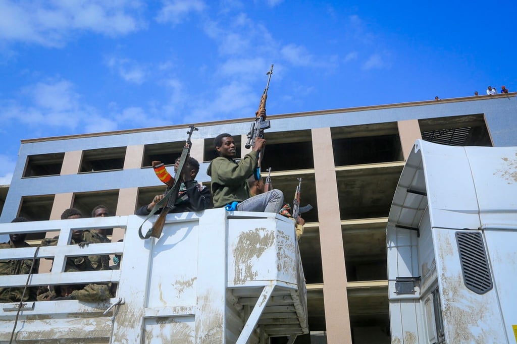 Bewaffnete Tigray-Streitkräfte begleiten gefangene äthiopische Regierungssoldaten und deren verbündete Milizangehörige in offenen Lastwagen auf der Fahrt zu einer Haftanstalt.
