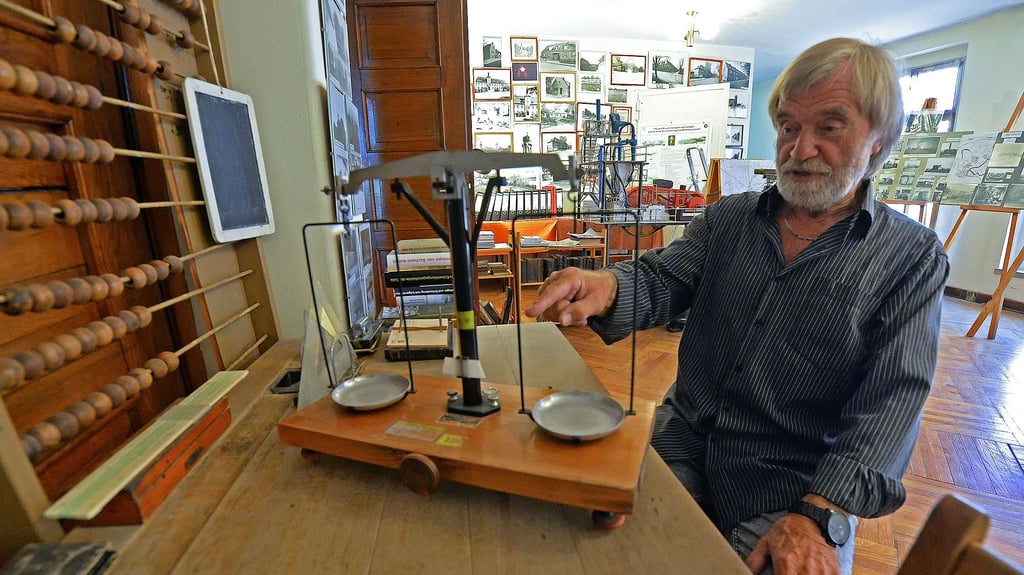 Horst Brückner hat in seinem Museum eine alte Schulbank stehen und viele Fotos an den Wänden.