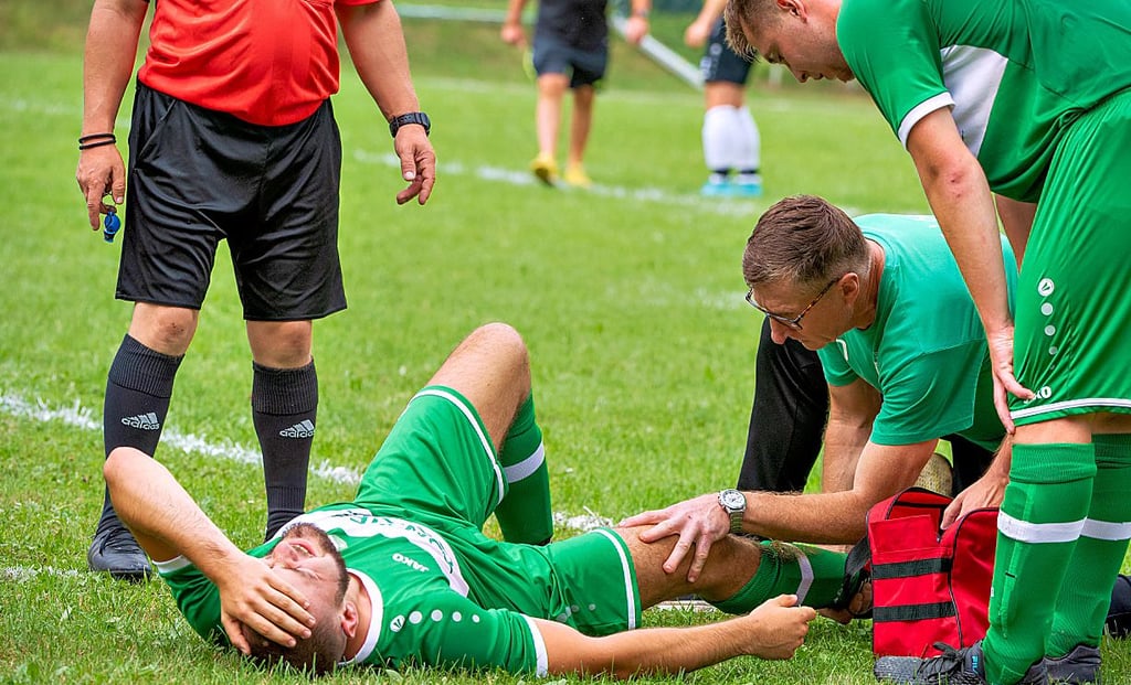 Behandlungspause nach einem Zusammenstoß: VSG-Trainer Frank Prater kümmert sich um Elias Gorges ...