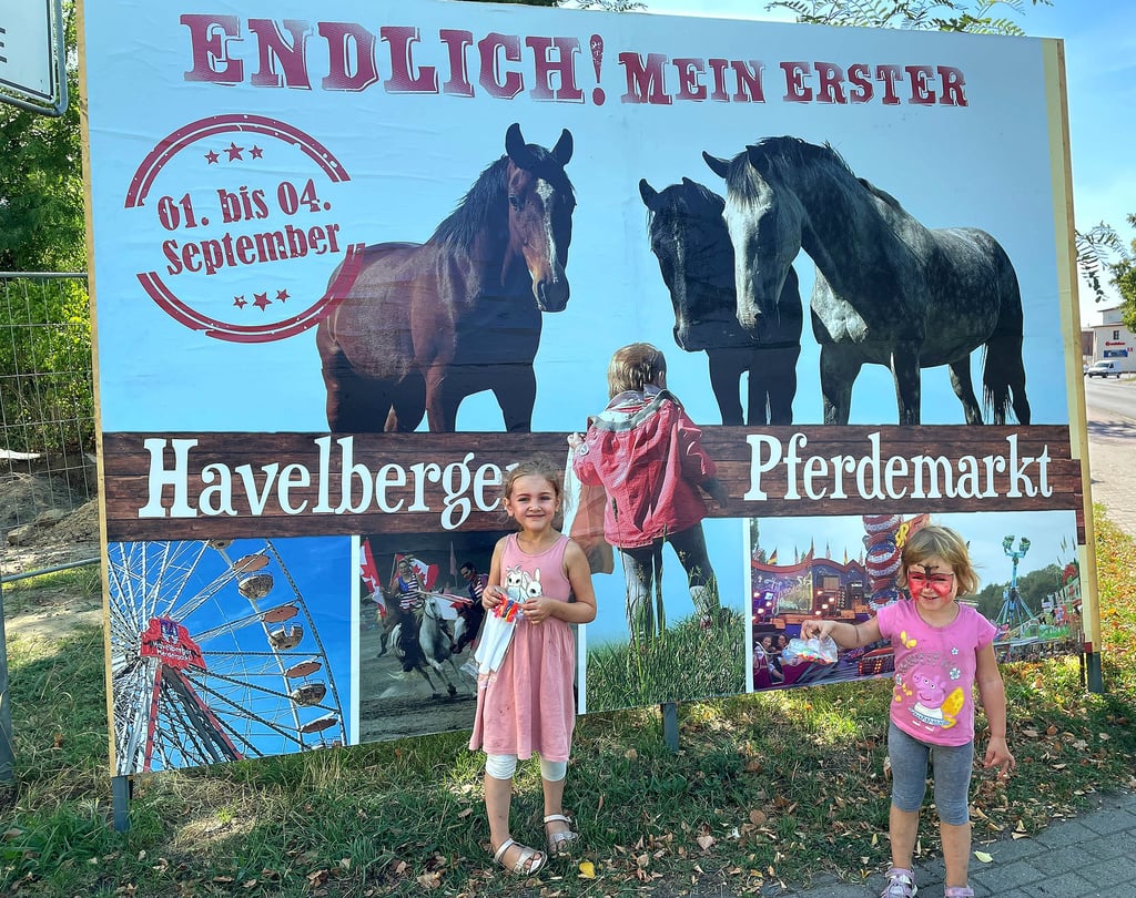 Mit großen Plakaten wirbt die Hansestadt Havelberg für ihr Großereignis. Ein Kind ist darauf zu sehen und der Schriftzug „Endlich! Mein erster Havelberger Pferdemarkt“. Clara ist die Lütte, die bisher auf den Markt verzichten musste. Denn als sie 2019 geboren wurde, war der letzte Pferdemarkt gerade wenige Tage vorbei. Danach gab es keinen mehr. Und Schwester Emma (6) kann sich kaum noch erinnern an ihren letzten Pferdemarkt. Beide freuen sich riesig, ab Donnerstag viele Tiere zu sehen und Karussell zu fahren, erzählt Mama Franziska Beck.